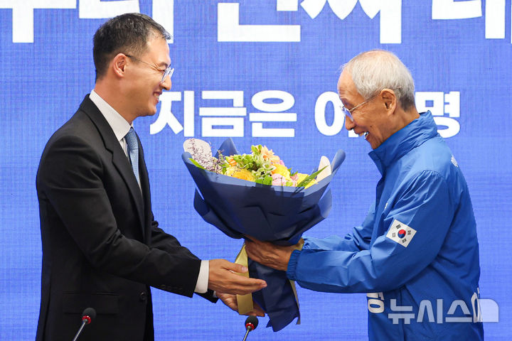 [서울=뉴시스] 권창회 기자 = 더불어민주당에 입당한 김상욱 의원이 19일 서울 여의도 더불어민주당 당사에서 열린 환영 입당식에서 윤여준 상임총괄선거대책위원장에게 꽃다발을 받고 있다. 2025.05.19. kch0523@newsis.com