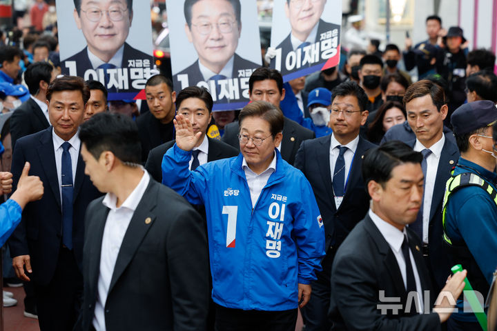 [서울=뉴시스] 권창회 기자 = 이재명 더불어민주당 대선 후보가 지난 19일 서울 마포구 KT&G 상상마당 인근에서 유세를 하기위해 이동하며 인사하고 있다. (공동취재) 2025.05.19. photo@newsis.com