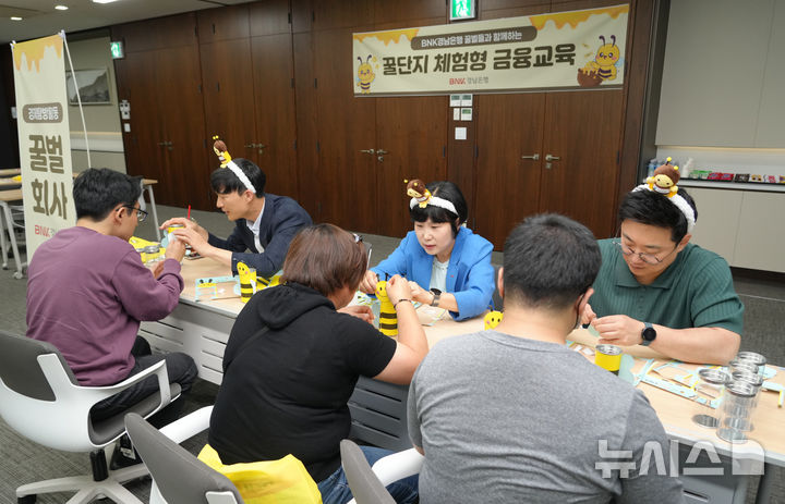 [창원=뉴시스]BNK경남은행은 지난 19일 창원 본점에서 금융감독원 경남지원과 함께 경상남도장애인종합복지관 소속 발달장애인 20여 명을 초청해 '꿀단지 체험형 금융교육'을 지원했다.(사진=BNK경남은행 제공)2025.05.20. photo@newsis.com