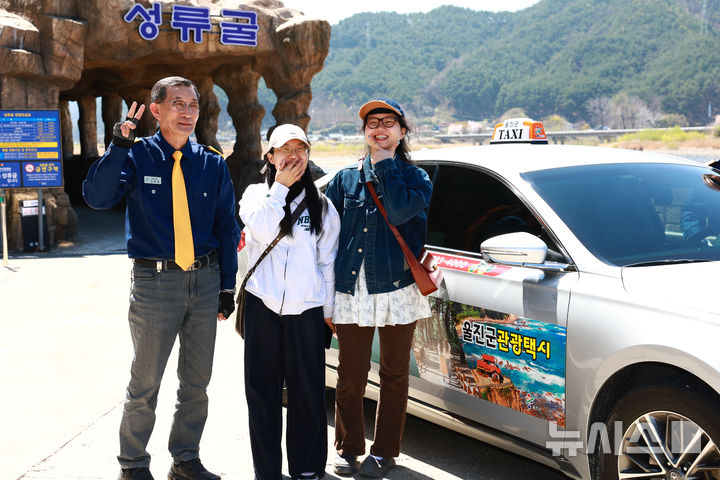관광객들이 관광택시 이용 전 기념 촬영을 하고 있다.(사진=울진군 제공)