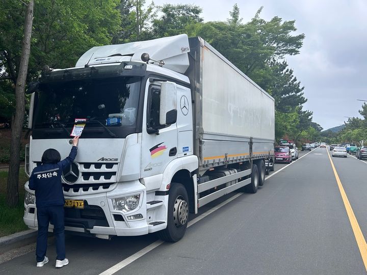 [창원=뉴시스] 강경국 기자 = 경남 창원시 진해구 경제교통과 직원들이 주차선 침범으로 주행차로 안전을 위협하는 차량에 대해 계도장을 부착하고 있다. (사진=창원시청 제공). 2025.05.20. photo@newsis.com *재판매 및 DB 금지