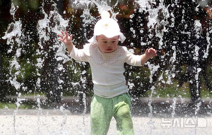 [대구=뉴시스] 이무열 기자 = 대구 낮 최고기온이 33도까지 오르며 무더운 날씨를 보인 20일 대구 서구 평리공원 바닥분수에서 아기가 물놀이를 하고 있다. 2025.05.20. lmy@newsis.com