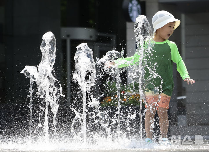[서울=뉴시스] 김명년 기자 = 초여름 날씨를 보인 20일 오후 서울 종로구 광화문 광장 분수대에서 아이가 물놀이를 하고 있다. 2025.05.20. kmn@newsis.com