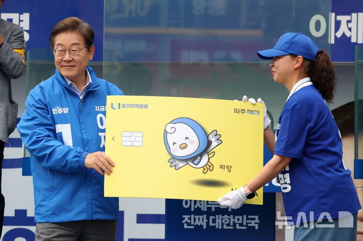 [파주=뉴시스] 조성우 기자 = 이재명 대통령이 지난달 20일 경기 파주시 금릉역 중앙광장에서 열린 유세에서 선거운동원으로부터 경기지역화폐 파주페이 모형을 받고 있다. 2025.05.20. xconfind@newsis.com
