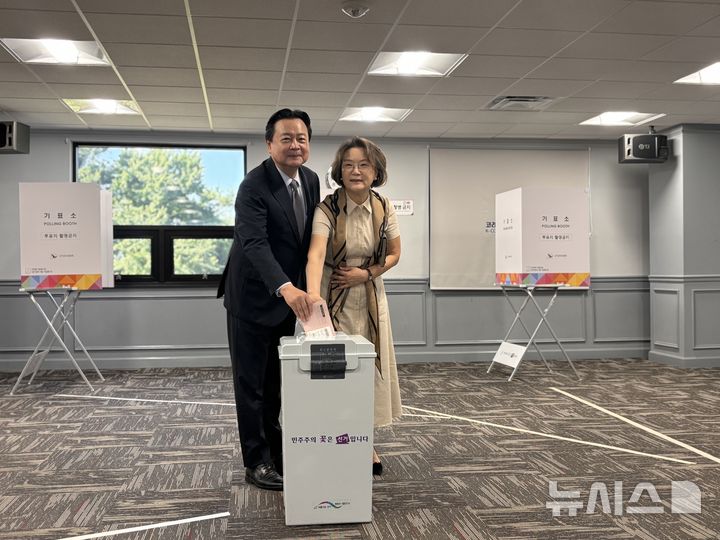 [워싱턴=뉴시스]이윤희 특파원 = 20일(현지 시간) 미국 버지니아주 알렉산드리아 코리안커뮤니티센터에 마련된 제21대 대통령선거 재외투표 투표소에서 조현동 주미대사 부부가 투표용지를 투표함에 넣기 전 취재진을 바라보고 있다. 이번 대선 재외선거는 이날부터 오는 25일까지 전 세계 118개국 223개 투표소에서 진행된다. 2025.05.21.