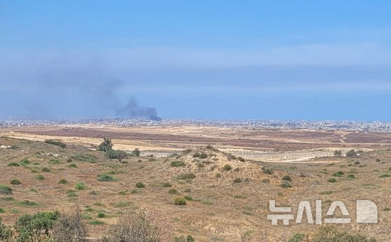 [스데로트=뉴시스]김난영 기자 = 21일(현지 시간) 이스라엘 남부 스데로트에서 바라본 가자 지구 모습. 건물 사이에서 검은 연기가 피어오르고 있다. 2025.05.21.