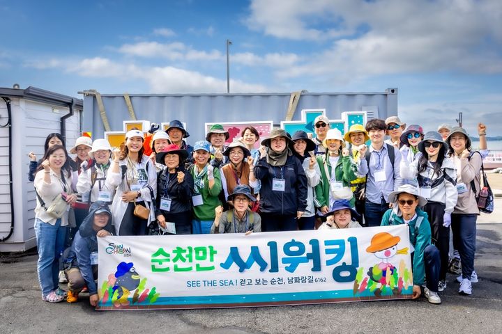 [순천=뉴시스] 남파랑길 따라 걷는 '순천만 씨워킹'참가자들이 기념촬영하고 있다, (사진=순천시 제공) 2025.05.21. photo@newsis.com *재판매 및 DB 금지