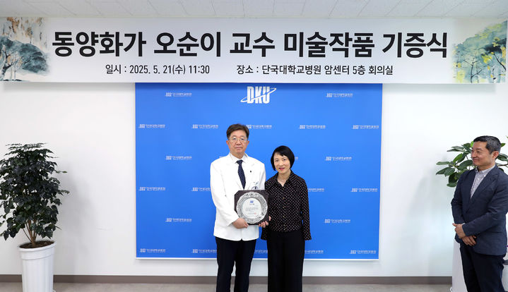 [천안=뉴시스] 오순이(오른쪽) 교수가 김재일(왼쪽) 단국대학교 병원장에게 한국화 작품 6점을 기증한 뒤 기념 사진을 촬영하고 있다. (사진=단국대병원 제공) 2025.5.21. photo@newsis.com *재판매 및 DB 금지