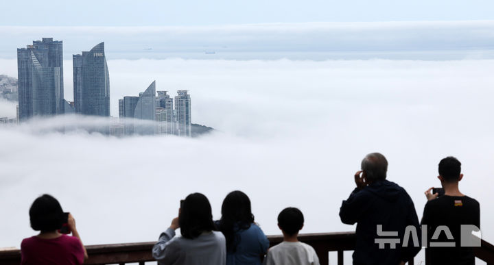 [부산=뉴시스] 하경민 기자 = 초여름 더위가 이어진 21일 부산 황령산의 한 전망대를 찾은 관광객들이 짙은 해무로 뒤덮인 도심을 구경하고 있다. 2025.05.21. yulnetphoto@newsis.com