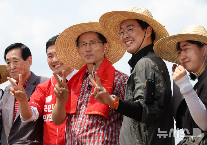 [고양=뉴시스] 고승민 기자 = 김문수 국민의힘 대선 후보가 21일 경기 고양시의 한 농가를 방문, 청년 농업인과 함께 이앙기를 이용해 모를 심기 전 기념촬영하고 있다. 2025.05.21. kkssmm99@newsis.com
