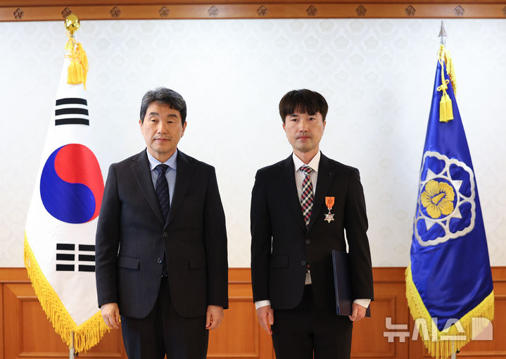 [서울=뉴시스] 최진석 기자 = 이주호 대통령 권한대행 부총리 겸 교육부 장관이 21일 정부서울청사에서 열린 적극행정 유공포상 수여식에서 임동희 경기 안양시 지방환경주사보에게 근정포장을 수여 뒤 기념촬영하고 있다. 2025.05.21. myjs@newsis.com