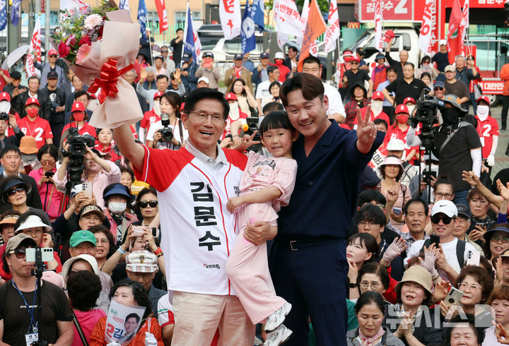 [동두천=뉴시스] 고승민 기자 = 김문수 국민의힘 대선 후보가 지난 21일 경기 동두천시 지행역 광장을 찾아 어린이 가족과 기념촬영하고 있다. 2025.05.21. kkssmm99@newsis.com