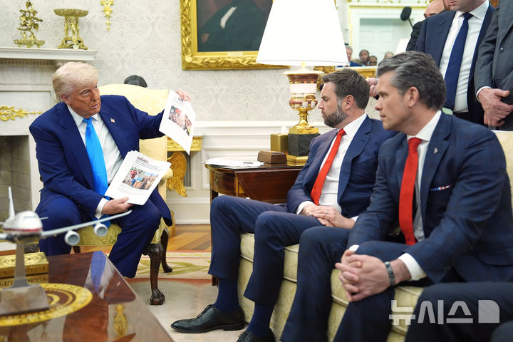 [워싱턴=AP/뉴시스] 도널드 트럼프(오른쪽) 미국 대통령이 21일(현지 시간) 백악관 집무실에서 시릴 라마포사 남아공 대통령과 회담하면서 자료를 공개하고 있다. 트럼프 대통령은 회담 중 남아공의 '백인 농부 집단 살해' 의혹을 공개적으로 제기, 해명을 요구하면서 정상 간 공방이 이어졌다. 2025.05.23.