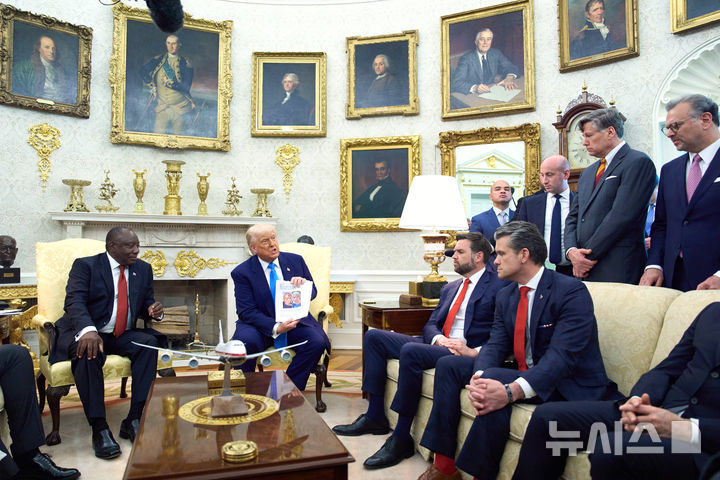 [워싱턴=AP/뉴시스] 도널드 트럼프(오른쪽) 미국 대통령이 21일(현지 시간) 백악관 집무실에서 시릴 라마포사 남아공 대통령과 회담하면서 자료를 공개하고 있다. 트럼프 대통령은 회담 중 남아공의 '백인 농부 집단 살해' 의혹을 공개적으로 제기, 해명을 요구하면서 정상 간 공방이 이어졌다. 2025.05.23.