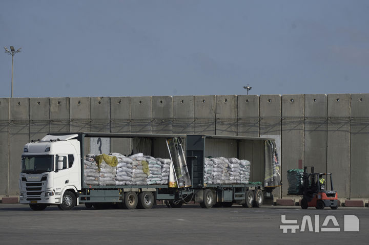 [AP/뉴시스] 22일 이스라엘 통제의 케렘 샬롬 통행문을 지나 가자 지구로 들어온 국제구호 트럭. 통행문 바로 뒤의 가자 땅에서 물자를 내려 다른 트럭으로 옮기는 작업을 하고 있다