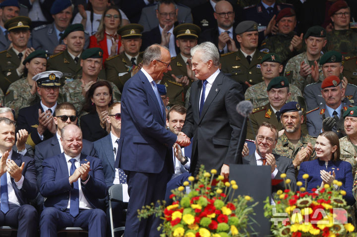 [빌뉴스=AP/뉴시스] 프리드리히 메르츠 독일 총리(왼쪽)가 22일(현지 시간) 리투아니아 빌뉴스에서 열린 독일 45기갑여단 출범식에서 기타나스 나우세다 리투아니아 대통령과 악수하고 있다. 독일이 외국에 자국군을 영구 배치하는 것은 2차 세계대전 후 이번이 처음이다. 2025.05.23.