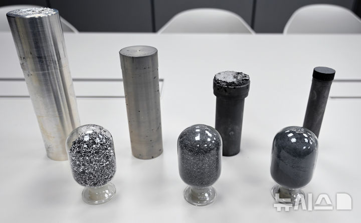 [창원=뉴시스]앞줄 원형 유리에 들어 있는 고체 수소 저장 소재 시편 중 왼쪽서 첫 번째는 기존 방법으로 제조한 시편. 두 번째·세 번째는 한국재료연구원 연구팀이 새롭게 개발한 방법으로 제조한 시편으로,기존보다 더 미세한(머리카락 절반 두께) 분말 형태를 나타내고 있다.(사진=한국재료연구원 제공) 2025.05.22. photo@newsis.com