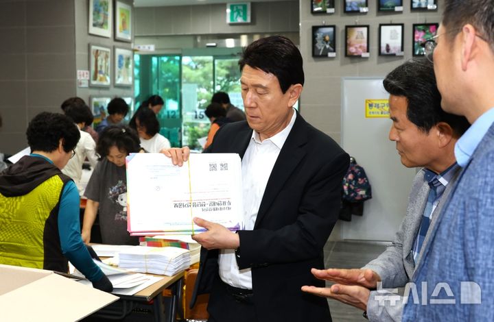 [포항=뉴시스] 송종욱 기자 = 이강덕 경북 포항시장이 22일 남구 오천읍행정복지센터를 방문해 선거 공보물 발송 작업을 하고 있는 현장 직원들과 봉사자를 격려했다. 사진은 선거 공보물 묶음을 들고 있는 이강덕 시장. (사진=포항시 제공) 2025.05.22. photo@newsis.com;