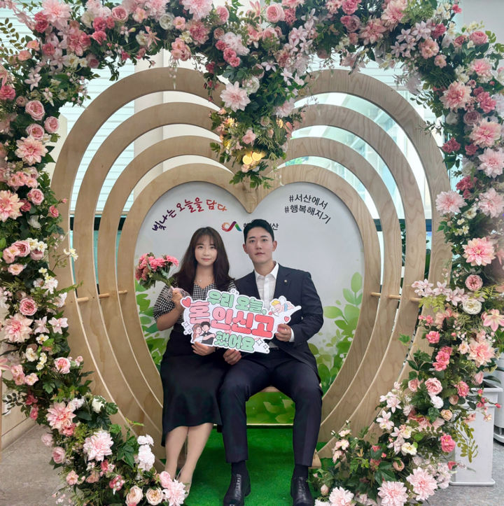 [서산=뉴시스] 충남 서산시 종합민원실에 마련된 포토존에서 21일 한 신혼부부가 혼인신고를 마친 후 기념 사진을 찍고 있다. (사진=서산시 제공) 2025.05.22. photo@newsis.com *재판매 및 DB 금지