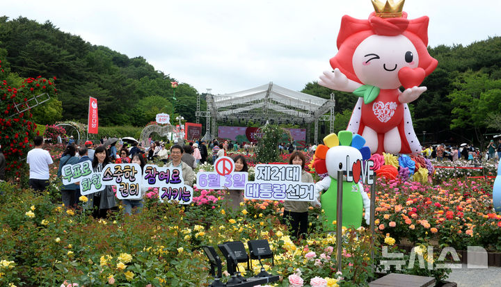 [울산=뉴시스] 배병수 기자 = 제21대 대통령선거를 앞둔 22일 울산 남구 대공원 장미축제가 열리고 있는 장미원 일원에서 울산광역시선거관리위원회 관계자들이 투표 독려 캠페인을 벌이고 있다. 2025.05.22.bbs@newsis.com.