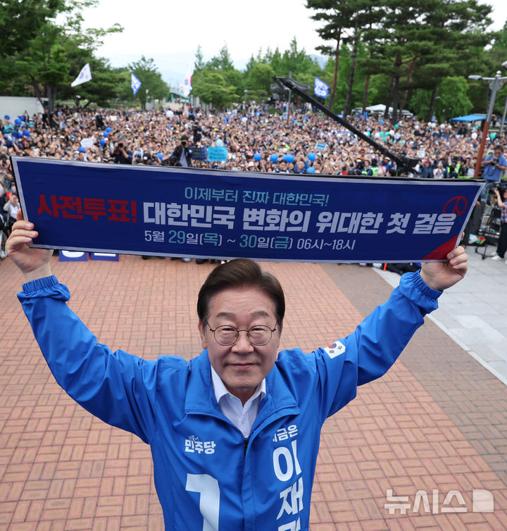 [양산=뉴시스] 조성우 기자 = 이재명 더불어민주당 대선후보가 22일 경남 양산시 양산워터파크공원에서 열린 집중유세에서 사전투표 독려 현수막을 전달 받은 뒤 들어보이고 있다. 2025.05.22. xconfind@newsis.com