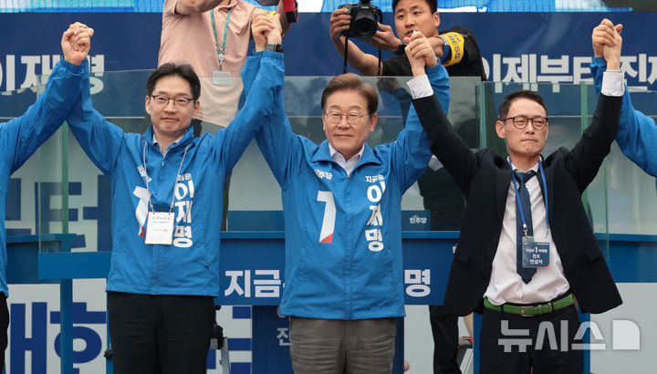 [양산=뉴시스] 조성우 기자 = 이재명 더불어민주당 대선후보가 22일 경남 양산시 양산워터파크공원에서 열린 집중유세에서 김경수(왼쪽) 총괄선대위원장과 찬조연설자의 손을 잡고 시민들을 향해 인사하고 있다. (공동취재) 2025.05.22. photo@newsis.com