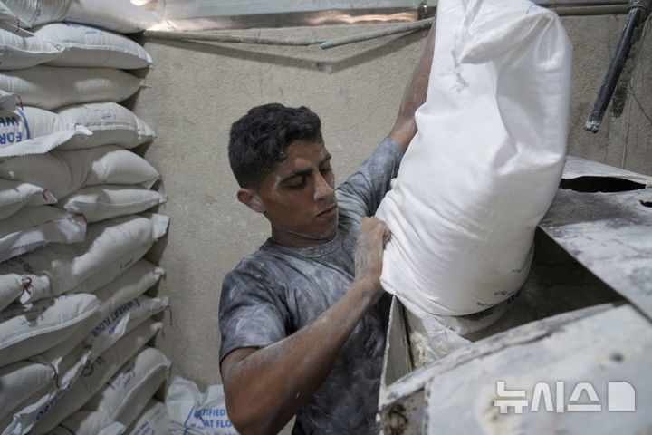 [데이르알발라=AP/뉴시스] 22일(현지 시간) 이스라엘이 일부 구호물자의 가자지구 반입을 허용함에 따라 세계식량계획(WFP)이 밀가루를 들여오자, 데이르알발라에서 팔레스타인 주민들이 빵을 굽고 있다. 2025.05.23.