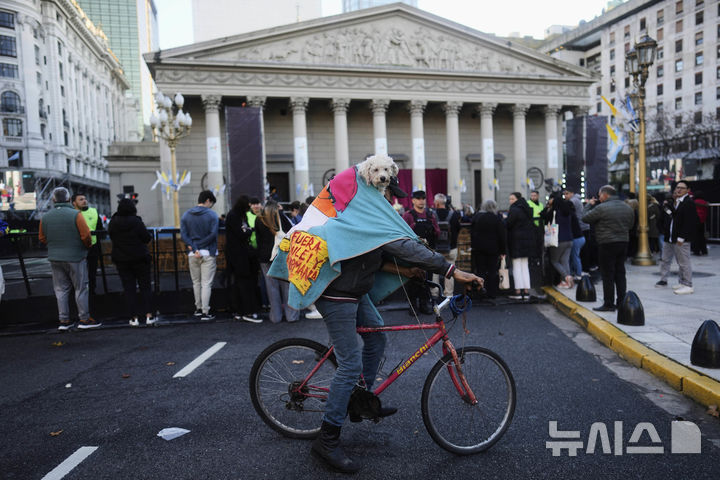 <font style="vertical-align: inherit;"><font style="vertical-align: inherit;">[부에노스아이레스=AP/뉴시스] 지난달 26일(현지 시간) 아르헨티나 부에노스아이레스에서 한 시민이 반려견을 업은 채 자전거를 타고 있다. 2025.05.23.</font></font>