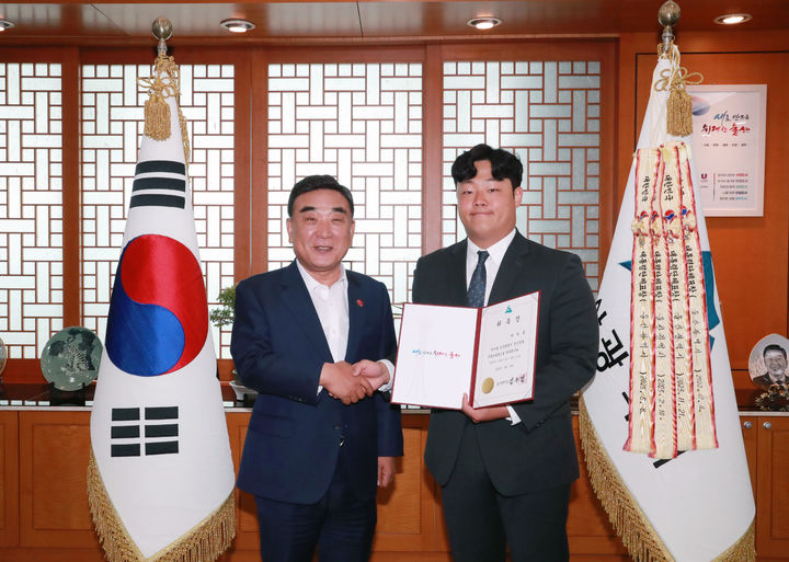 [울산=뉴시스] 김두겸 울산시장(왼쪽)이 23일 시장 집무실에서 박지홍 울산대학교 총학생회장에게 청년정책특별보좌관 위촉패를 전달한 뒤 함께 기념촬영을 하고 있다. (사진=울산시 제공) 2025.05.23. photo@newsis.com *재판매 및 DB 금지