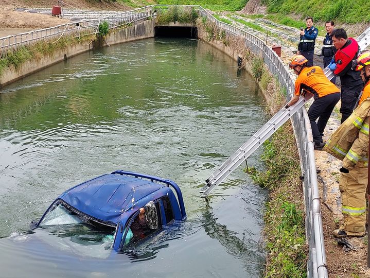 [정읍=뉴시스] 23일 낮 12시9분께 전북 정읍시 덕천면의 한 마을 안 도로를 지나던 1t 트럭이 가드레일을 들이받고 수로로 추락해 트럭에 갇힌 운전자를 소방대원이 구조하고 있다. (사진=전북도소방본부 제공) 2025.05.23. photo@newsis.com *재판매 및 DB 금지