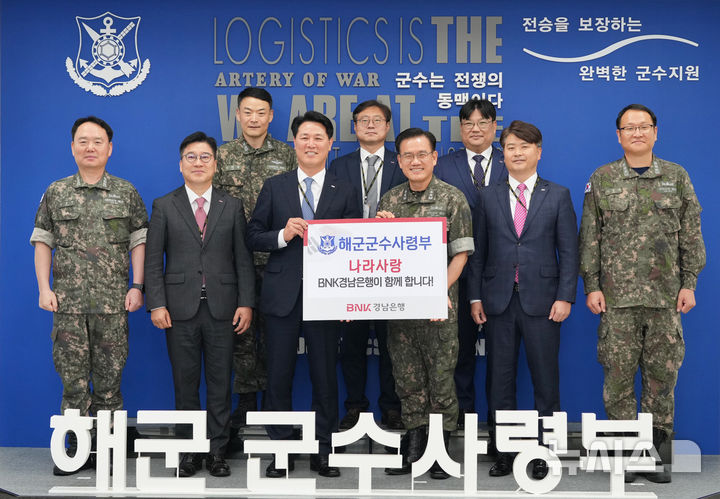 [창원=뉴시스]BNK경남은행 김태한(앞줄 왼쪽서 세 번째) 은행장이 23일 창원시 진해구 해군군수사령부를 방문해 안상민 사령관에게 위문금을 전달하고 있다.(사진=BNK경남은행 제공) 2025.05.23. photo@newsis.com