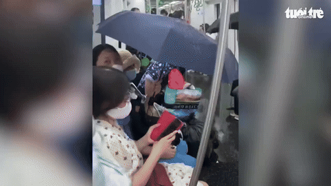[뉴시스] 베트남 하노이의 한 지하철에서 에어컨 배수구 고장으로 객실 안으로 물이 쏟아지면서 승객들이 우산을 펼쳐 쓰고 있는 모습.(사진＝tuoitre) *재판매 및 DB 금지 *재판매 및 DB 금지