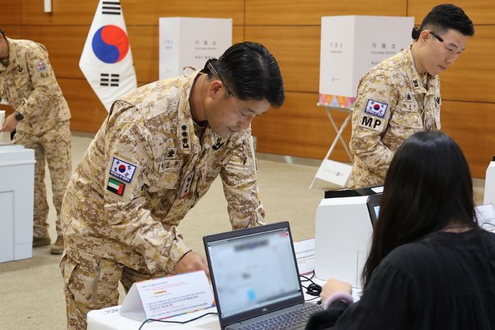 [서울=뉴시스] 아랍에미리트(UAE)에 파병중인 아크부대가 지난 20일부터 21일까지(현지 시간) 주UAE 대한민국 대사관에 마련된 제21대 대통령선거 재외투표소에서 투표하기 앞서 신분 확인을 하고 있다. (사진=합참 제공) 2025.05.23. photo@newsis.com *재판매 및 DB 금지