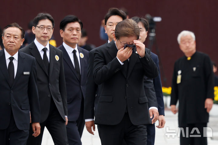 [김해=뉴시스] 조성우 기자 = 이재명 더불어민주당 대선후보가 고 노무현 전 대통령 16주기인 23일 경남 김해시 진영읍 봉하마을을 찾아 노 전 대통령의 묘역을 참배한 이동하며 눈물을 훔치고 있다. 2025.05.23. xconfind@newsis.com
