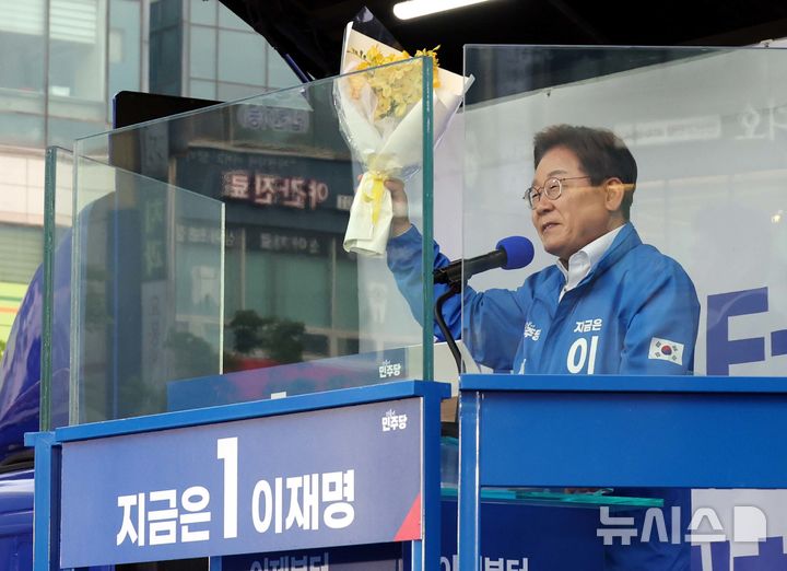 [안산=뉴시스] 조성봉 기자 =  이재명 더불어민주당 대선 후보가 24일 경기 안산 단원구 안산문화광장에서 열린 유세에서 세월호 유가족에게 받은 꽃을 들고 지지를 호소하고 있다.  2025.05.24.suncho21@newsis.com