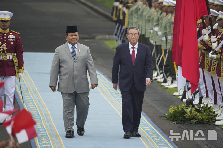 [AP/뉴시스] 중국의 리창 총리가 25일 인도네시아 자카르타 메르데카궁에 도착해 푸라보워 수비안토 대통령의 환영을 받고 의장대를 사열하고 있다