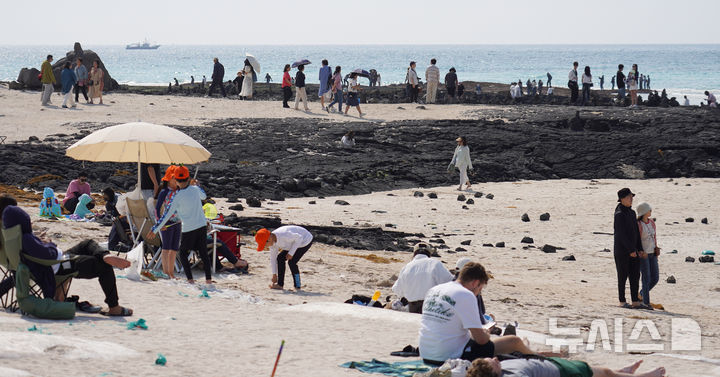 [제주=뉴시스] 우장호 기자 = 맑은 날씨를 보인 25일 오후 제주시 한림읍 협재해수욕장을 찾은 관광객들이 때 이른 여름 정취를 만끽하고 있다. 2025.05.25. woo1223@newsis.com