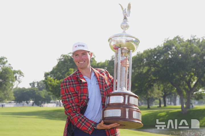 [포트워스=AP/뉴시스] 벤 그리핀(미국)이 25일(현지 시간) 미 텍사스주 포트워스의 콜로니얼 컨트리클럽에서 열린 미국프로골프(PGA) 투어 찰스 슈왑 챌린지 정상에 올라 격자무늬 재킷을 입고 트로피와 함께 포즈를 취하고 있다. 그리핀은 최종 합계 12언더파 268타를 기록하며 우승컵을 들어 올렸다. 2025.05.26.