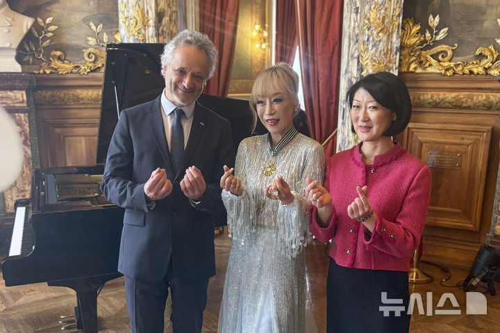 [파리=AP/뉴시스]소프라노 가수 조수미(가운데)가 26일 파리에서 프랑스 최고 등급의 코망되르 훈장을 받은 뒤 플레르 펠레린 전 문화부장관(오른쪽) 및 루이 랭리 오페라 코미크 극장 감독과 함께 제스처를 취하고 있다. 2025.05.26.