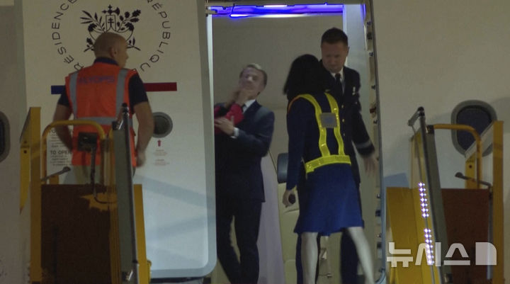 [AP/뉴시스] 비디오 사진으로 25일 저녁 하노이 공항에 도착한 프랑스의 마크롱 대통령이 내릴 채비를 하다 빨간 소매에 밀침을 당하고 있다