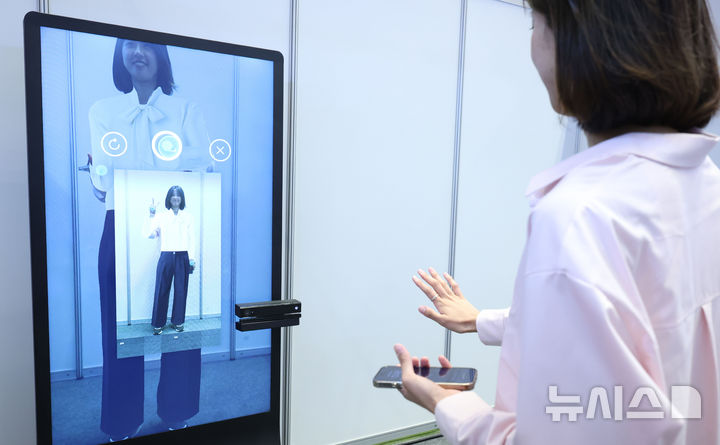 [서울=뉴시스] 조수정 기자 = 26일 서울 강남구 코엑스에서 열린 2025 제1차 KB굿잡 우수기업 취업박람회에서 취업준비생이 AI 의상 추천을 받고 있다. 2025.05.26. chocrystal@newsis.com