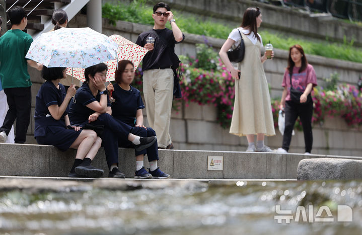 [서울=뉴시스] 황준선 기자 = 서울의 한낮 기온이 26도를 넘는 등 초여름 날씨를 보인 26일 서울 중구 청계천에서 양산을 쓴 시민들이 휴식을 취하고 있다. 2025.05.26. hwang@newsis.com