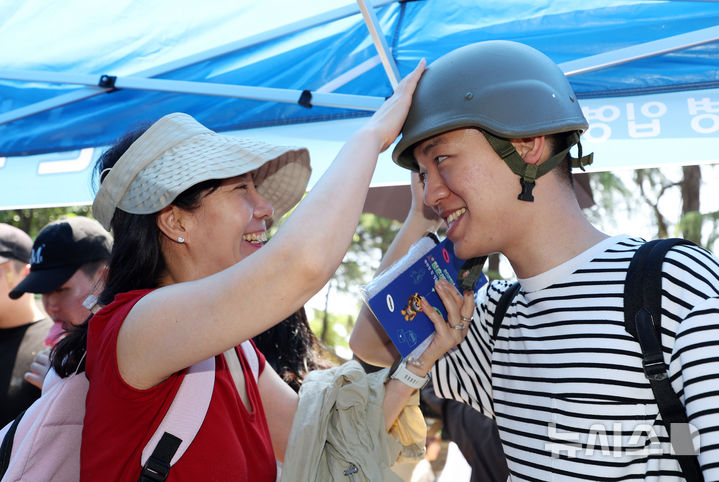 [논산=뉴시스] 김명년 기자 = 26일 오후 충남 논산 육군훈련소에서 열린 현역병 입영 행사에서 입영장정 어머니가 아들에게 방탄모를 씌워주고 있다. 2025.05.26. kmn@newsis.com