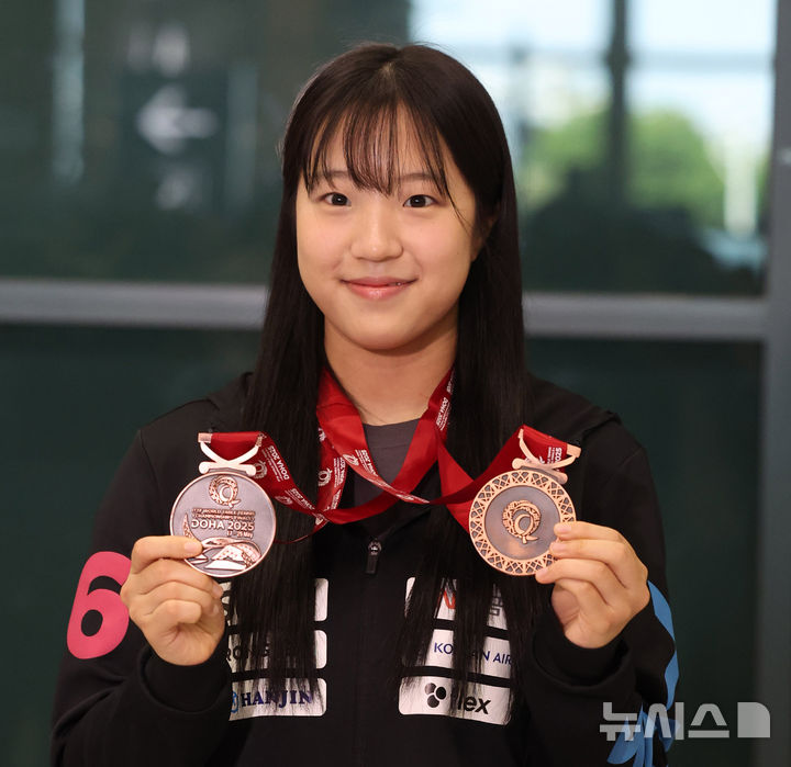[인천공항=뉴시스] 추상철 기자 = 2025 국제탁구연맹(ITTF) 세계선수권대회에서 동메달 2개를 획득한 신유빈이 26일 오후 인천국제공항 제1터미널을 통해 귀국한 후 메달을 들어 보이고 있다. 025.05.26. scchoo@newsis.com