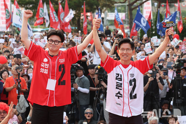 [서울=뉴시스] 권창회 기자 = 김문수 국민의힘 대선 후보가 26일 서울 도봉구 방학사거리 인근에서 열린 집중유세에서 한동훈 전 국민의힘 대표와 손을 맞잡고 있다. 2025.05.26. kch0523@newsis.com