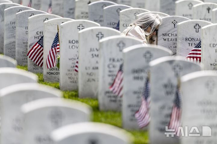 <font style="vertical-align: inherit;"><font style="vertical-align: inherit;">[홀리 타운십=AP/뉴시스] 지난 25일(현지 시간) 미 미시간주 홀리 타운십에 있는 그레이트 레이크스 국립묘지에서 한 여성이 메모리얼 데이(현충일) 추념식 후, 미 육군 소속이던 남편의 묘비에 기대어 고인을 추모하고 있다. 이 여성의 남편은 지난 2011년 고엽제 후유증으로 세상을 떠났다. 2025.05.27.</font></font>