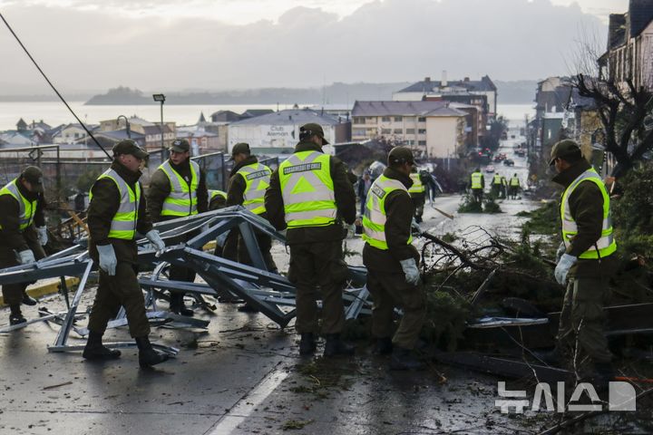 [푸에르토 바라스( 칠레)=AP/뉴시스]대규모 토네이도가 휩쓸고 간 칠레 남부도시 푸에르토 바라스에서 5월 26일 경찰이 잔해물에 뒤덮인 도로를 치우고 있다. 2025. 05. 27. 