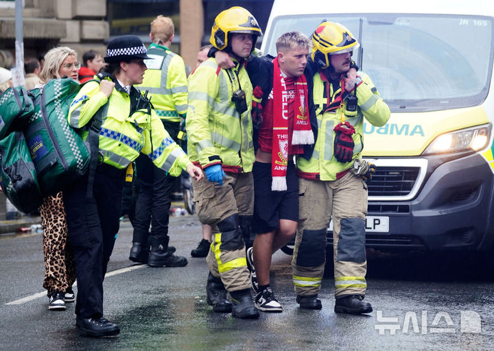 [리버풀=AP/뉴시스] 26일(현지 시간) 영국 리버풀 워터 스트리트에서 열린 리버풀FC의 프리미어리그(EPL) 우승 축하 퍼레이드 현장에서 군중들 사이로 차량이 돌진하는 사고가 발생해 소방대원과 경찰이 부상자를 이송하고 있다. 2025.05.27.