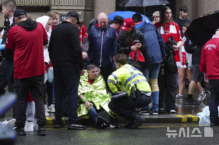 [리버풀=AP/뉴시스] 26일(현지 시간) 영국 리버풀 워터 스트리트에서 열린 리버풀FC의 프리미어리그(EPL) 우승 축하 퍼레이드 현장에서 군중들 사이로 차량이 돌진하는 사고가 발생해 소방대원과 경찰이 부상자를 이송하고 있다. 2025.05.27.