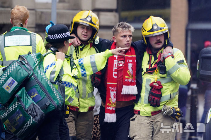 [리버풀=AP/뉴시스] 26일(현지 시간) 영국 리버풀 워터 스트리트에서 열린 리버풀FC의 프리미어리그(EPL) 우승 축하 퍼레이드 현장에서 군중들 사이로 차량이 돌진하는 사고가 발생해 소방대원과 경찰이 부상자를 이송하고 있다. 2025.05.27.
